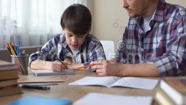 <strong>关爱</strong>的父亲帮助他的小儿子做家庭作业，父亲的支持，教育